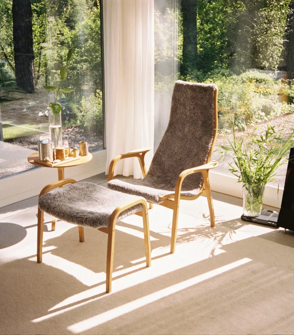 Fåtölj och fotpall klädda i fårskinn i en ljus miljö